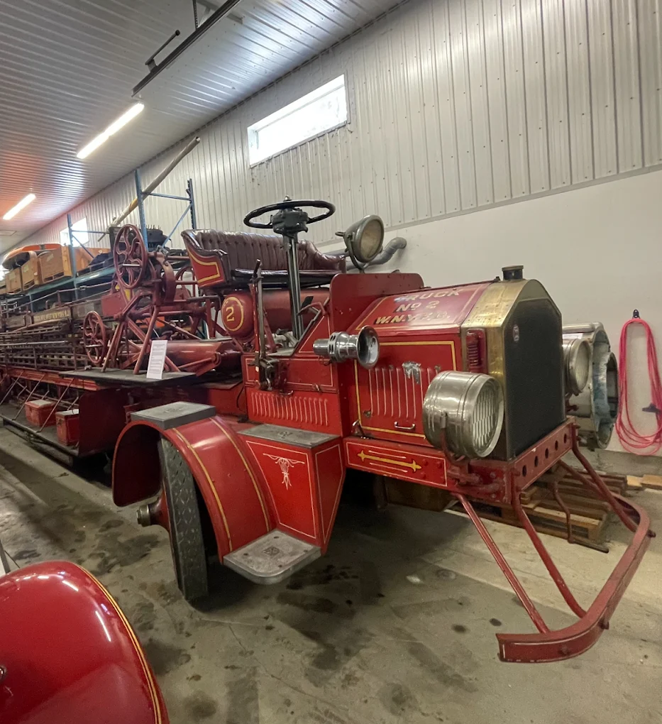 Classic red car being loaded into an enclosed transport trailer